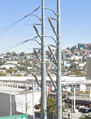 Configuración original con terminales de porcelana y apartarrayos montados sobre la caña del poste de transición de 115 kV